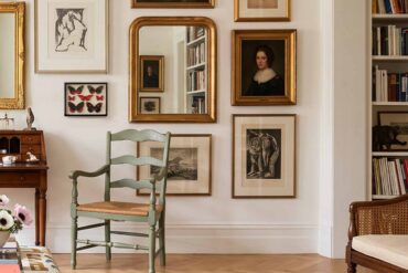 pared llena de cuadros diferentes en living con biblioteca para diseño de interior de estilo
